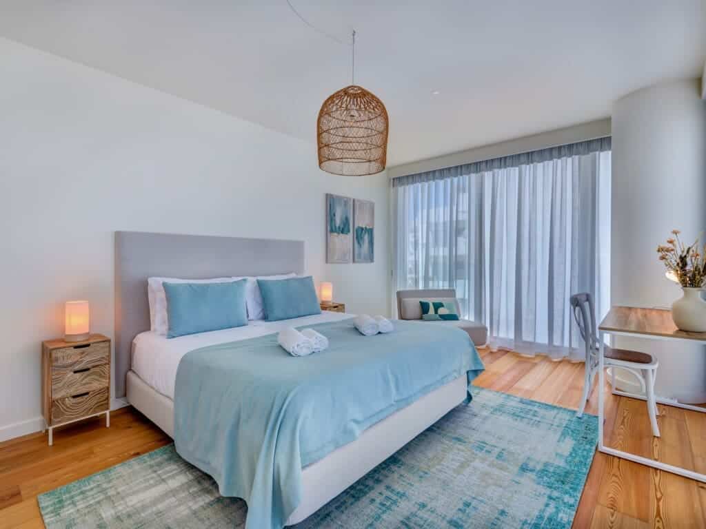 bliss & spa bedroom at Bayline, Armação de Pêra: double bed with blue throw, rattan pendant and sheer curtains
