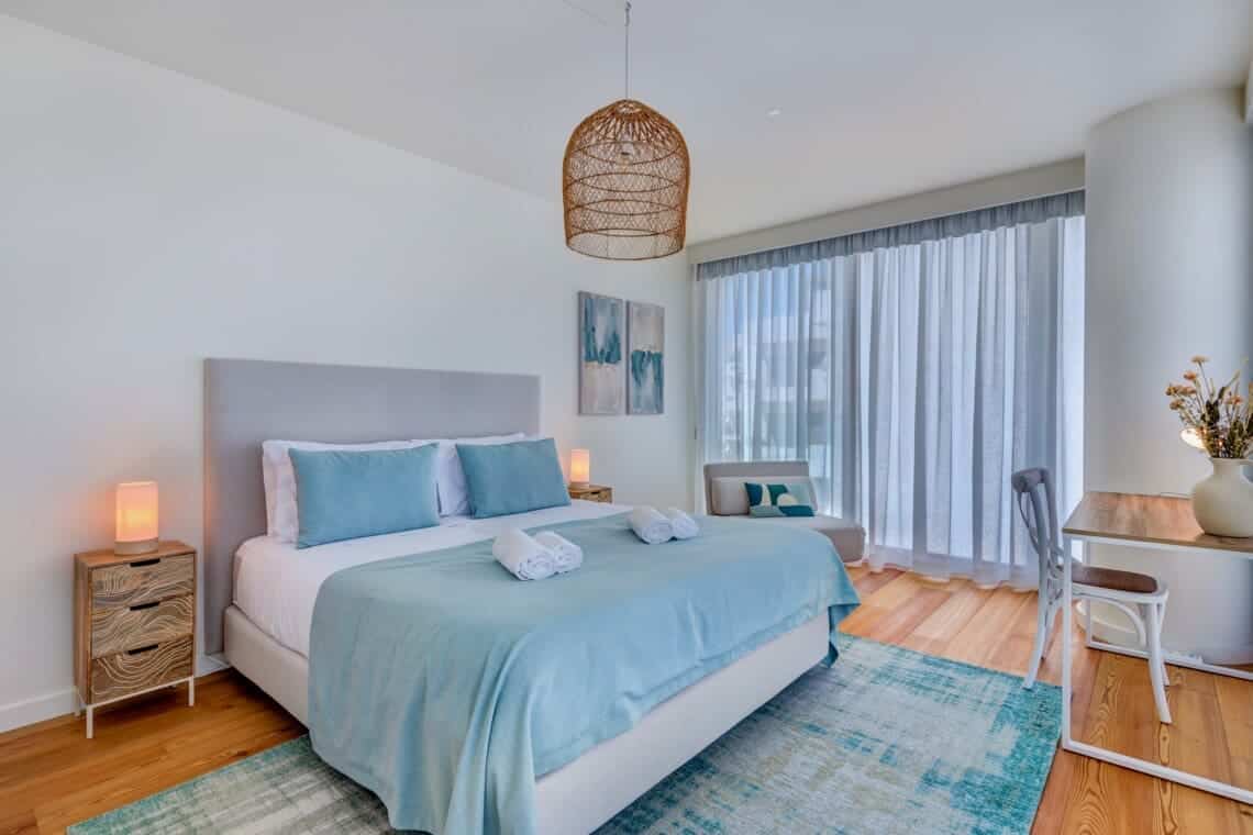 bliss & spa bedroom at Bayline, Armação de Pêra: double bed with blue throw, rattan pendant and sheer curtains