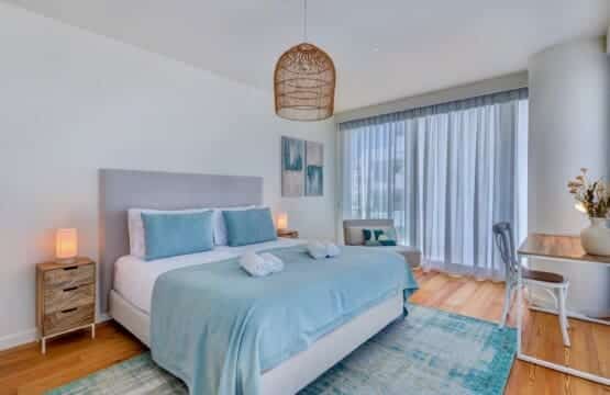 bliss & spa bedroom at Bayline, Armação de Pêra: double bed with blue throw, rattan pendant and sheer curtains