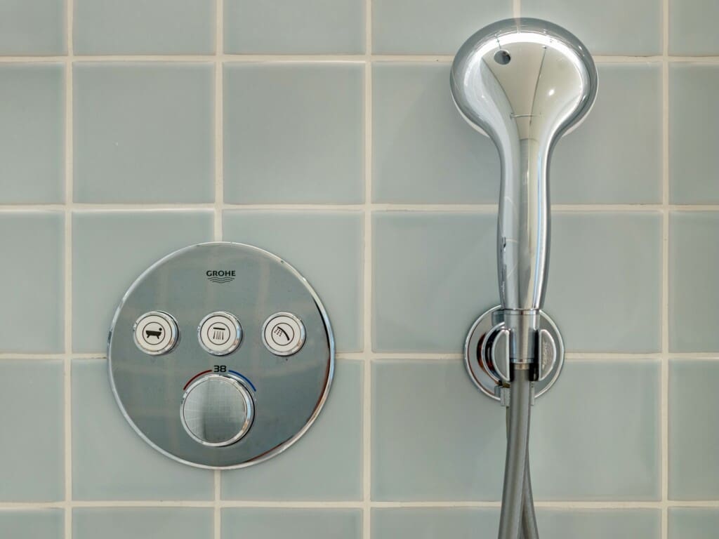 bliss & spa bathroom at Bayline, Armação de Pêra: thermostatic shower controls and hand shower on blue tiles