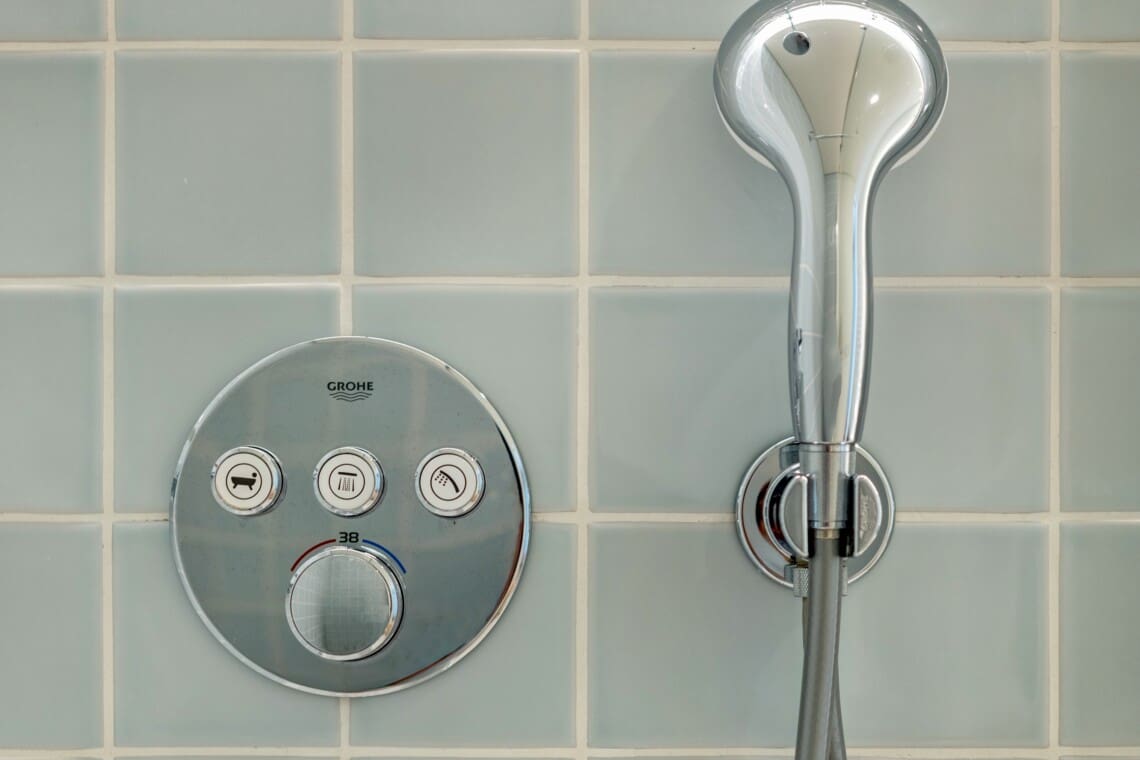 bliss & spa bathroom at Bayline, Armação de Pêra: thermostatic shower controls and hand shower on blue tiles