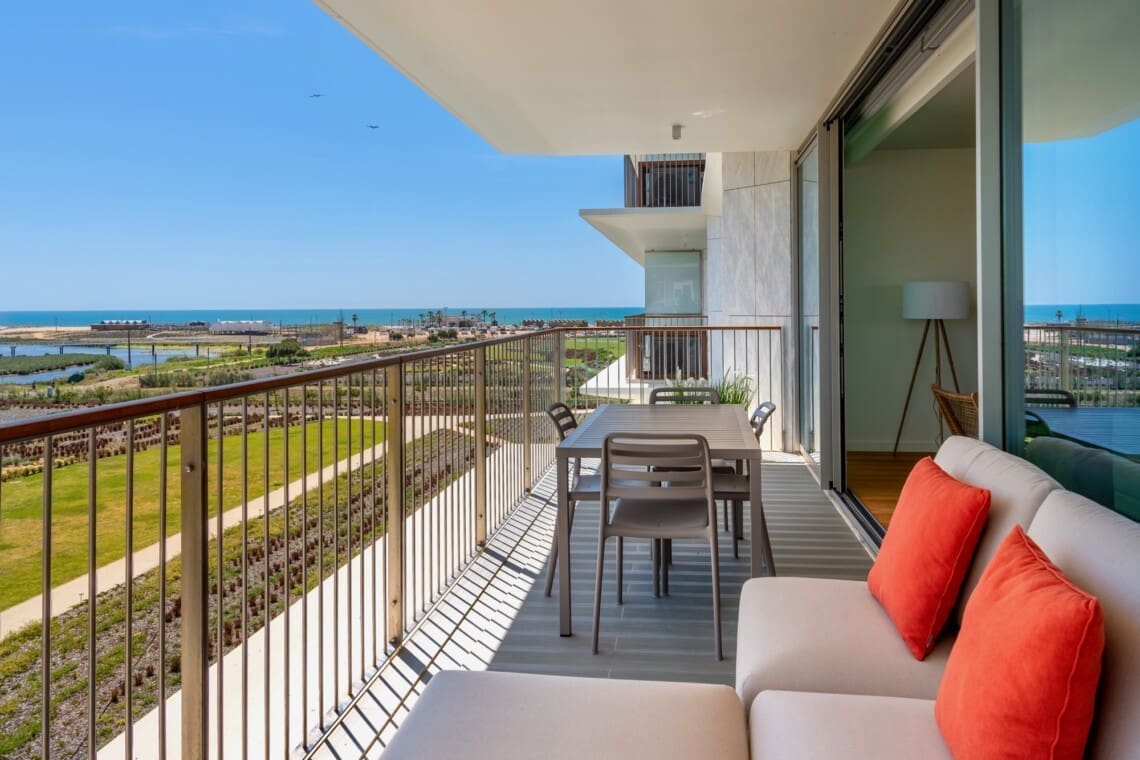 bliss & spa balcony at Bayline, Armação de Pêra: lounge sofa with coral cushions and dining table, view towards the sea