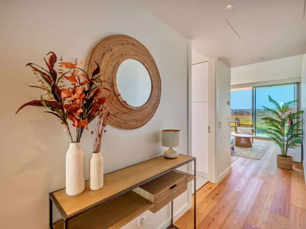 bliss & spa at Bayline, Armação de Pêra: entrance console with dried flowers and rattan mirror, living room beyond