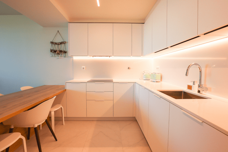 Salmão kitchen at Bayline, Armação de Pêra: white L-shaped kitchen and wooden dining table