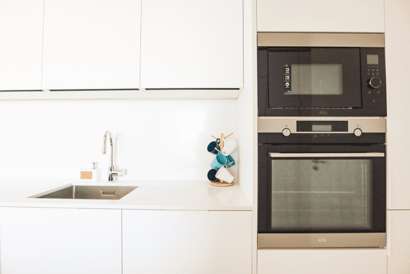 Salmão kitchen at Bayline, Armação de Pêra: built-in oven and microwave beside a white fitted kitchen