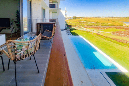 Salmão balcony at Bayline, Armação de Pêra: rattan chairs overlooking the pool and the lagoon landscape