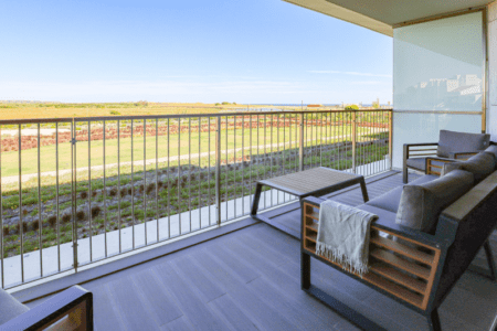Cavala balcony at Bayline, Armação de Pêra: outdoor sofa and coffee table overlooking open countryside