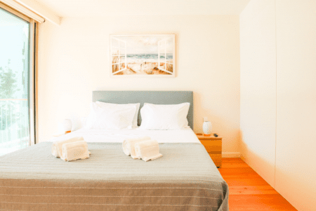 Cavala bedroom at Bayline, Armação de Pêra: double bed with grey headboard, rolled towels and beach print