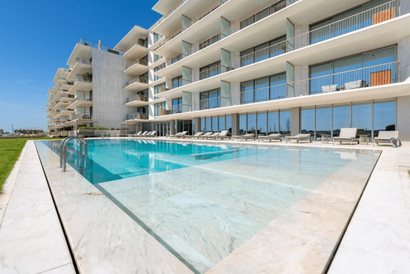 Bayline condominium pool in Armação de Pêra: outdoor pool with sun loungers in front of the apartment blocks