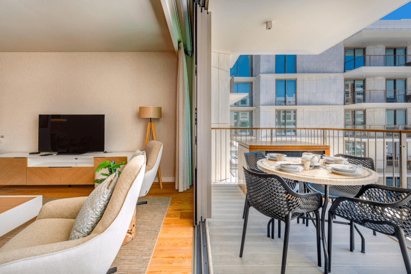 Pargo A at Bayline, Armação de Pêra: living room opening onto the balcony with outdoor dining table