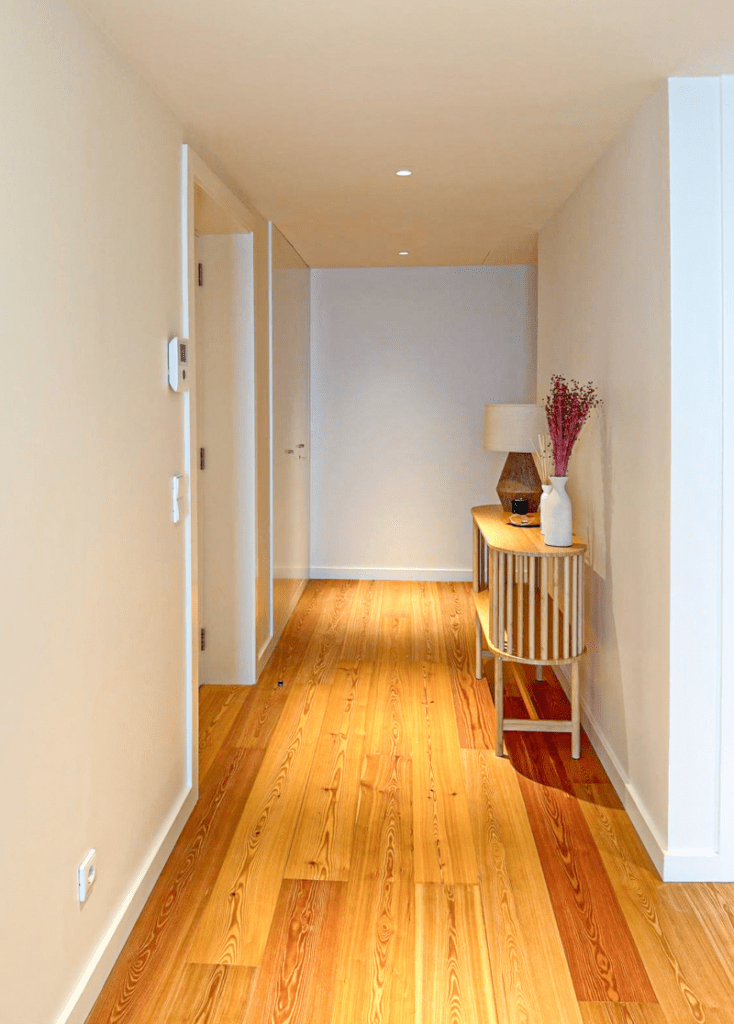 Robalo at Bayline, Armação de Pêra: hallway with wooden floor and a console table with lamp and dried flowers