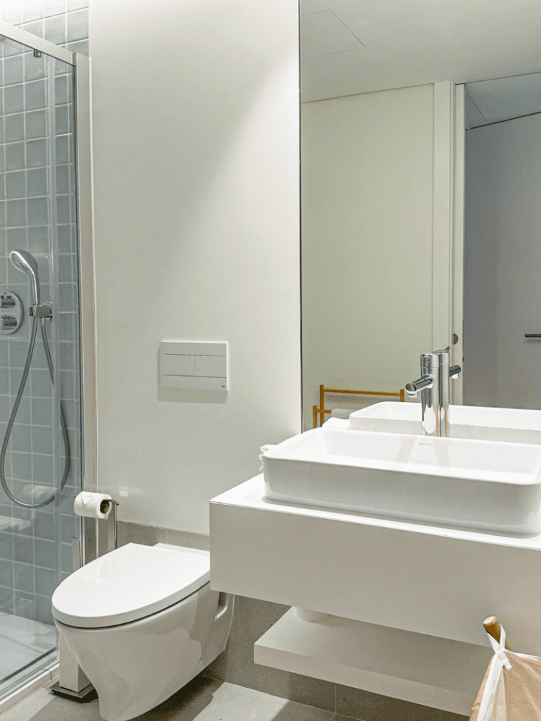 Robalo bathroom at Bayline, Armação de Pêra: vessel basin on a floating shelf, wall-hung toilet and shower