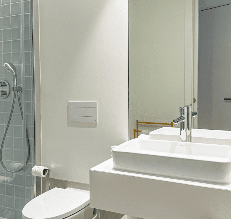 Robalo bathroom at Bayline, Armação de Pêra: vessel basin on a floating shelf, wall-hung toilet and shower