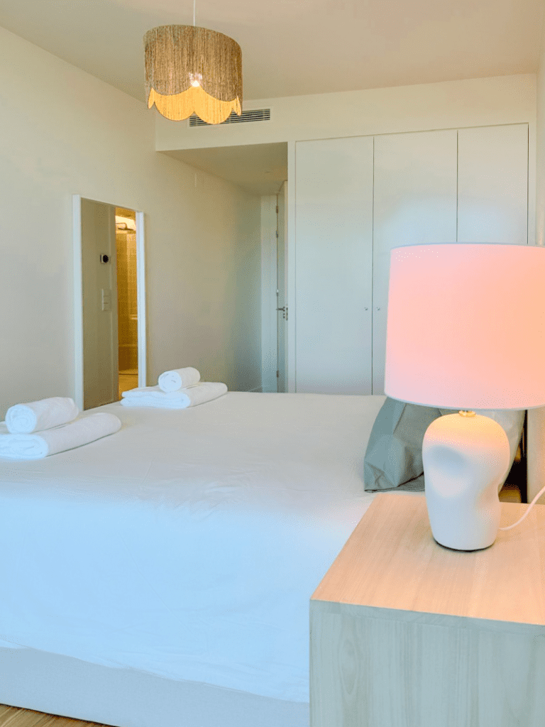 Robalo bedroom at Bayline, Armação de Pêra: double bed with rolled towels, ceramic lamp and built-in wardrobe