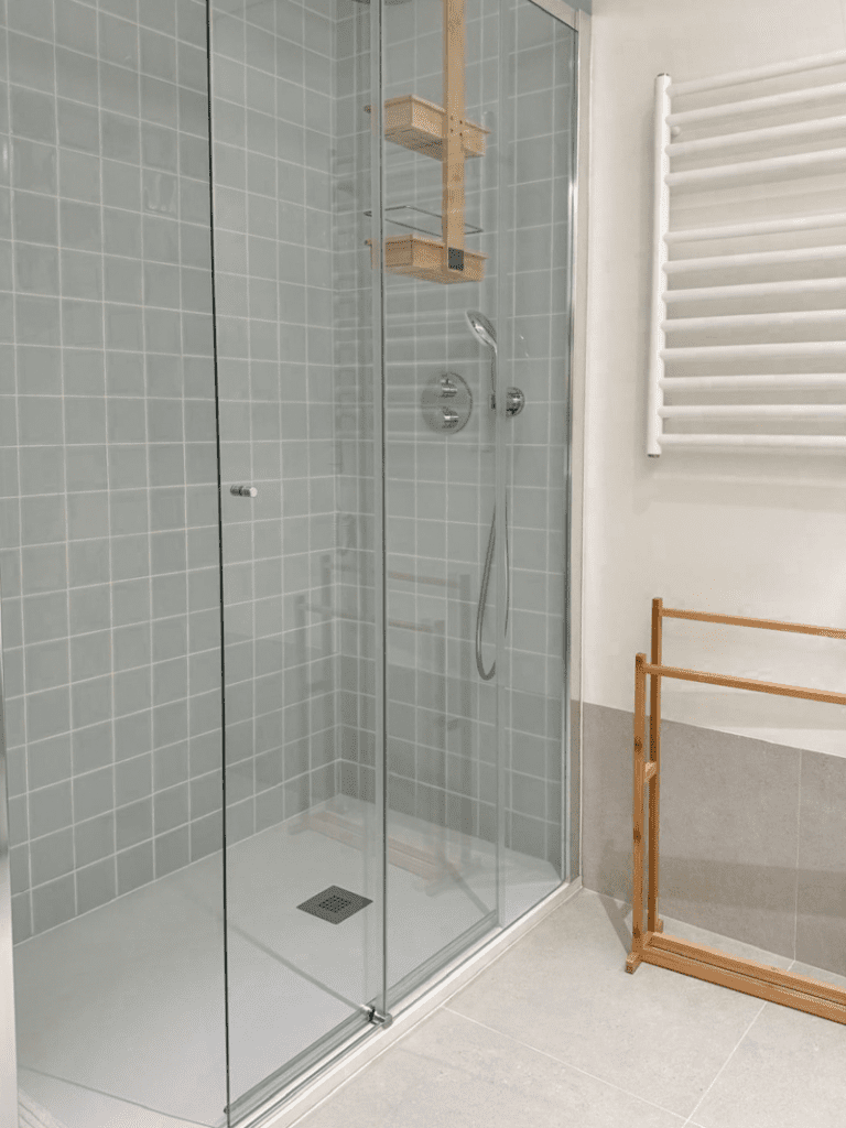 Robalo bathroom at Bayline, Armação de Pêra: glass walk-in shower with grey tiles and heated towel rail