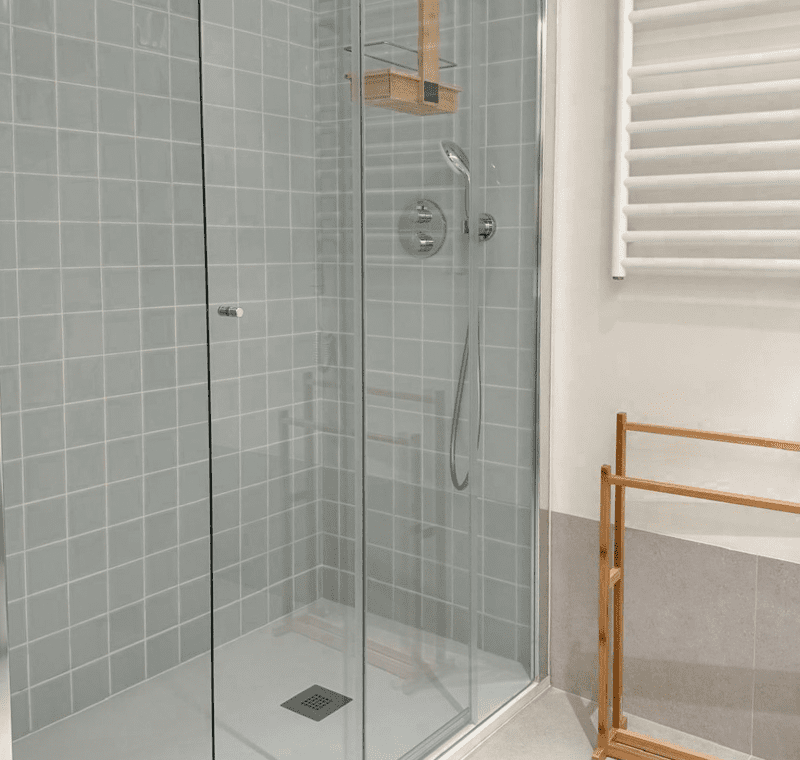 Robalo bathroom at Bayline, Armação de Pêra: glass walk-in shower with grey tiles and heated towel rail