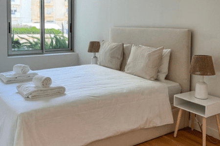 Robalo bedroom at Bayline, Armação de Pêra: double bed with upholstered headboard and rattan lamps