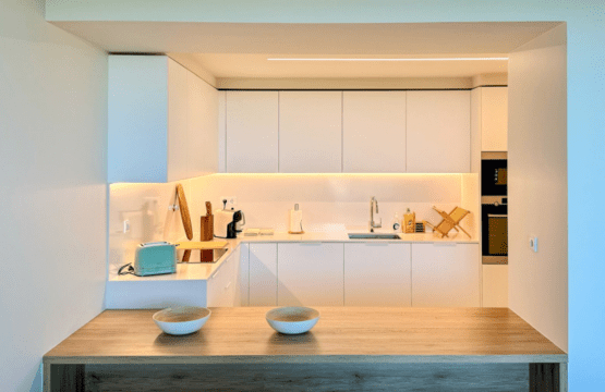 Robalo kitchen at Bayline, Armação de Pêra: white fitted kitchen and wooden breakfast bar