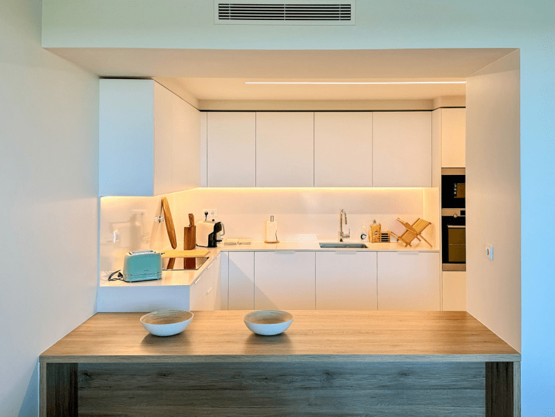 Robalo kitchen at Bayline, Armação de Pêra: white fitted kitchen and wooden breakfast bar