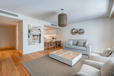 Linguado living room at Bayline, Armação de Pêra: sofas and coffee table, kitchen with breakfast bar behind