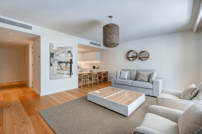 Linguado living room at Bayline, Armação de Pêra: sofas and coffee table, kitchen with breakfast bar behind