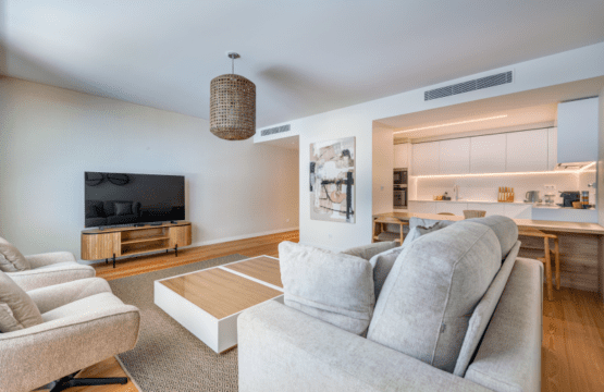 Linguado at Bayline, Armação de Pêra: sofas and TV in the living room, open kitchen with breakfast bar behind