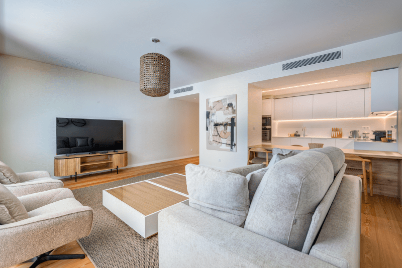 Linguado at Bayline, Armação de Pêra: sofas and TV in the living room, open kitchen with breakfast bar behind