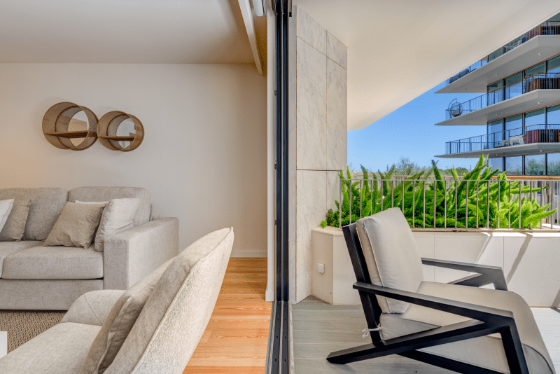 Linguado at Bayline, Armação de Pêra: living room sofa and balcony armchair beside a planted terrace