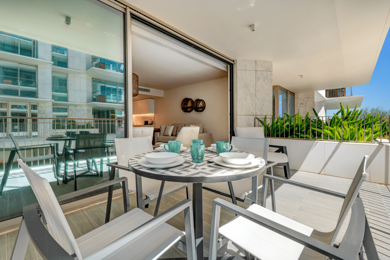 Linguado balcony at Bayline, Armação de Pêra: outdoor dining table set for four, living room beyond