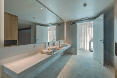 Washroom at Bayline, Armação de Pêra: long stone counter with two basins and a wide mirror