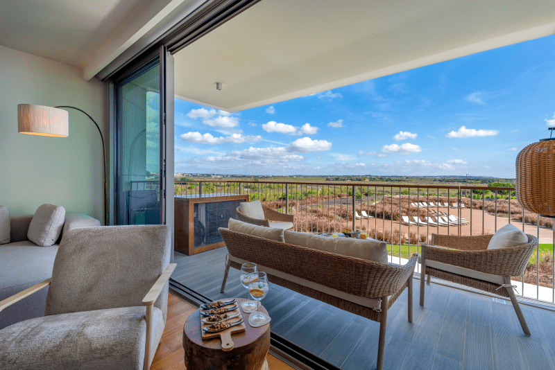 Raia balcony at Bayline, Armação de Pêra: rattan lounge set with a wide view over the countryside