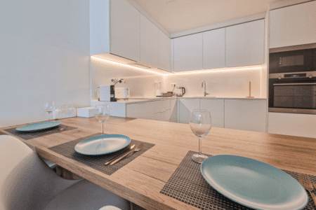 Bacalhau kitchen at Bayline, Armação de Pêra: white fitted kitchen and wooden dining table set for two