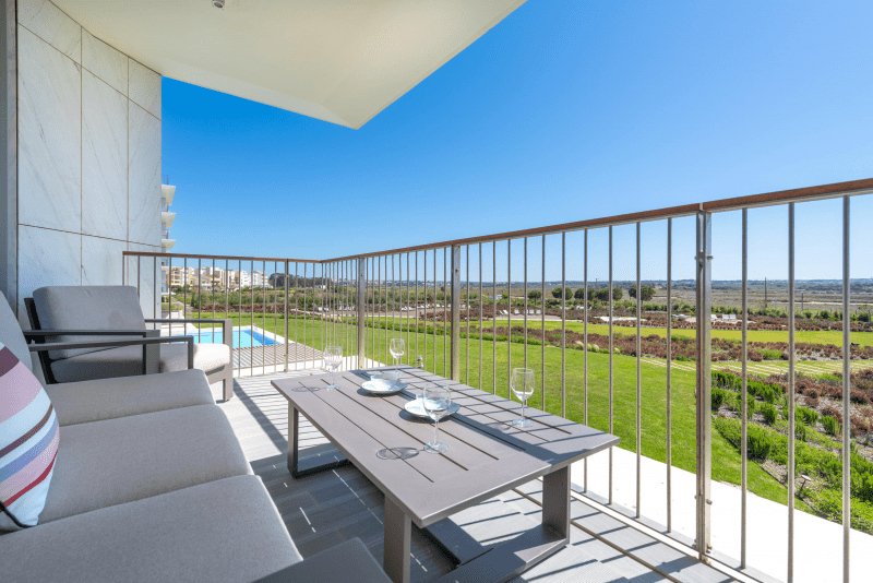Enguia balcony at Bayline, Armação de Pêra: outdoor sofa and table overlooking the gardens and pool