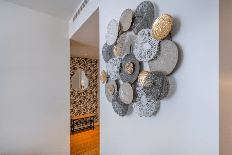 Peixe Balão at Bayline, Armação de Pêra: decorative wall piece in the hallway, leaf-print wallpaper beyond