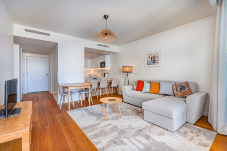 Corvina living room at Bayline, Armação de Pêra: corner sofa with colourful cushions, dining area and kitchen