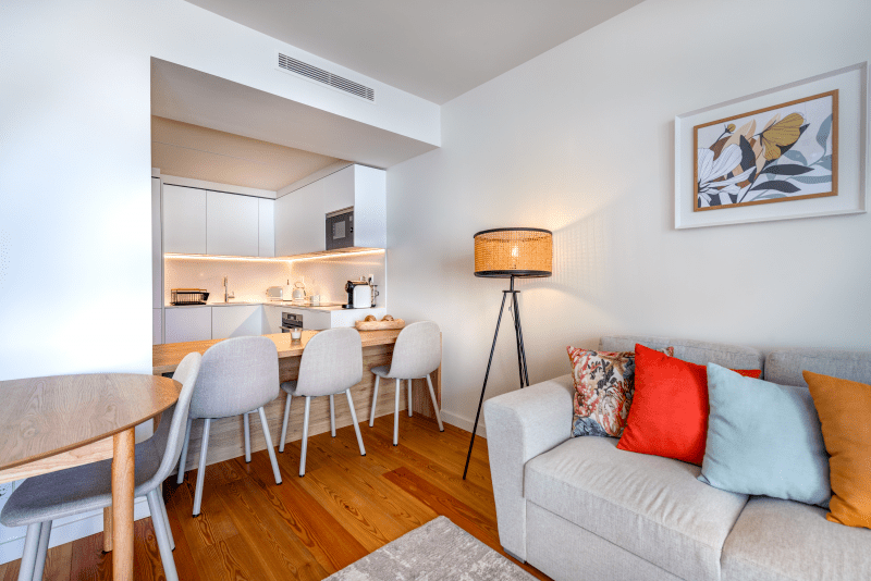 Corvina at Bayline, Armação de Pêra: sofa with colourful cushions, dining table and kitchen breakfast bar