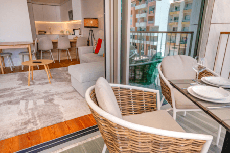 Corvina balcony at Bayline, Armação de Pêra: wicker chairs and a table set for two, living room beyond