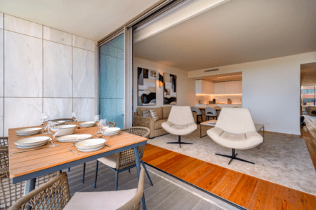 Ostra balcony at Bayline, Armação de Pêra: table set for dinner, with the living room seen through the open doors