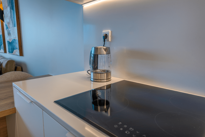 Ostra kitchen at Bayline, Armação de Pêra: induction hob and kettle on a white worktop
