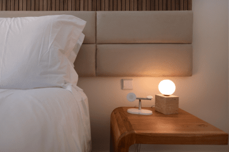 Sardinha bedroom at Bayline, Armação de Pêra: upholstered headboard, wooden bedside table and globe lamp
