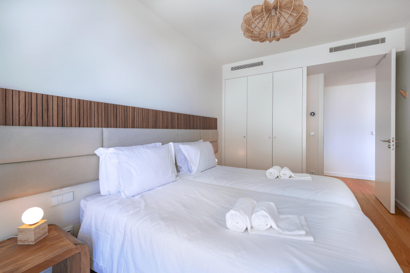 Sardinha bedroom at Bayline, Armação de Pêra: two single beds pushed together, wooden headboard and built-in wardrobe