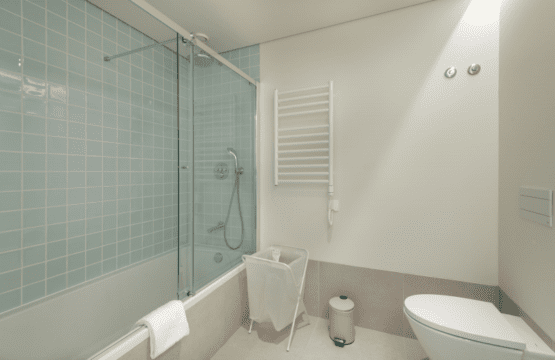 Sardinha bathroom at Bayline, Armação de Pêra: bathtub with glass screen, blue tiles and heated towel rail