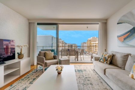 Safia living room at Bayline, Armação de Pêra: sofa, armchair and coffee table facing the balcony with dining table