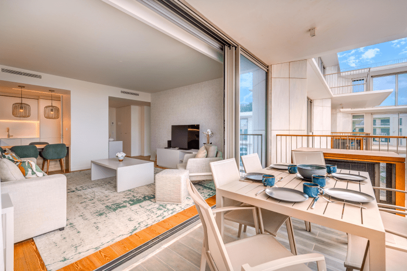 Safia balcony at Bayline, Armação de Pêra: dining table laid for four, living room through the open doors