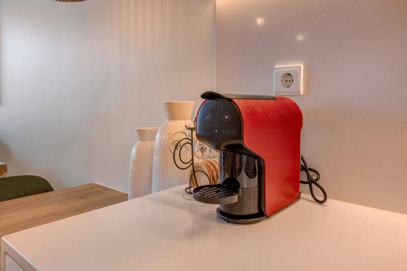 Safia kitchen at Bayline, Armação de Pêra: red capsule coffee machine on a white worktop