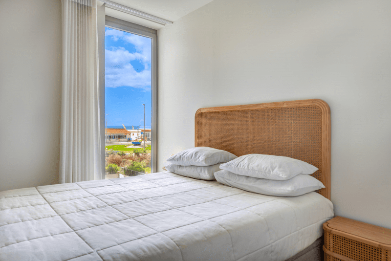 Faneca bedroom at Bayline, Armação de Pêra: double bed with rattan headboard and tall window