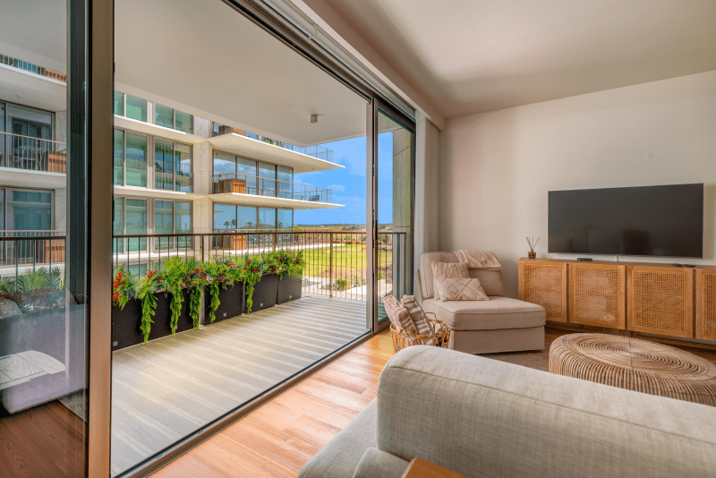 Faneca living room at Bayline, Armação de Pêra: open sliding doors to a planted balcony, TV and sofas