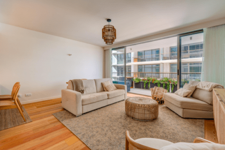 Faneca living room at Bayline, Armação de Pêra: two sofas and a rattan pouf facing the balcony