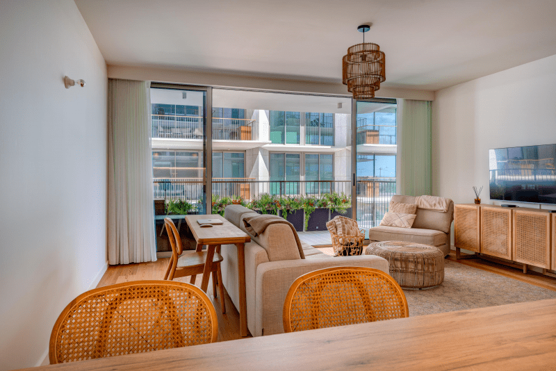 Faneca living room at Bayline, Armação de Pêra: rattan dining chairs, sofas and glass doors to the balcony