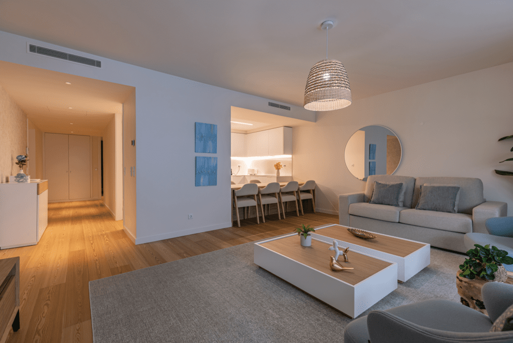 Bezugo living room at Bayline, Armação de Pêra: sofa and coffee tables with the kitchen and dining area behind